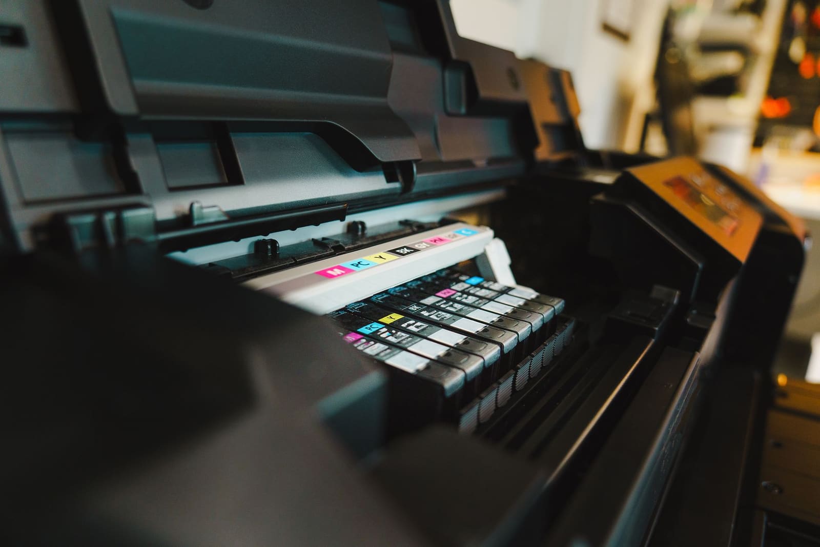 Rij inktcartridges in cyaan, magenta, geel en zwart in een printer