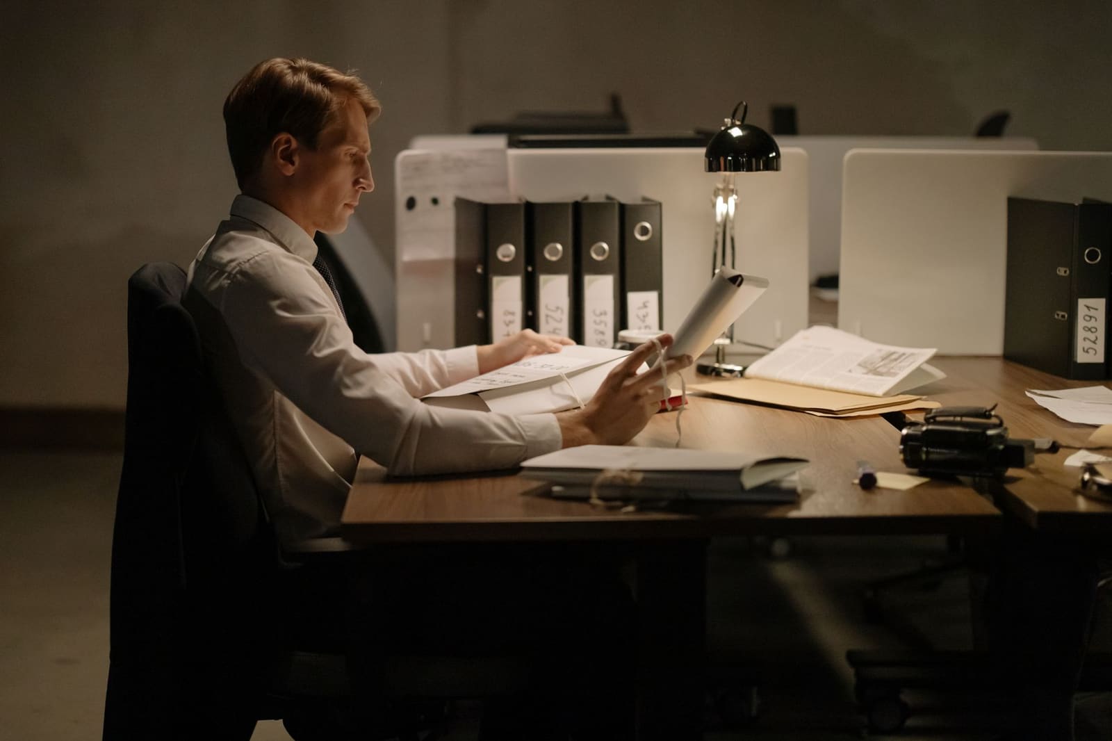 Iemand aan een bureau die afgedrukte stukken doorneemt